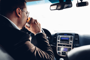 driver drinking coffee behind the wheel
