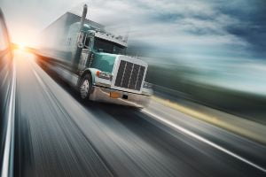 green truck racing down road