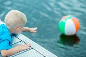 boy trying to get a ball in a pool