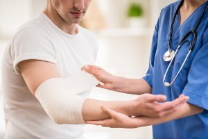 doctor checking patient with arm in bandage