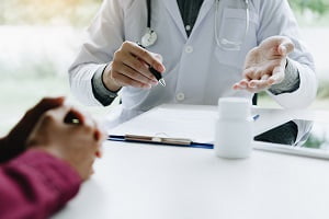 Doctor talking to the patient about suggest the properties of medicines in clinic office