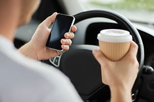 driver with cup of coffee in hand