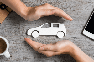 hands surrounding toy car