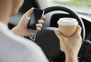 holding phone and coffee while driving