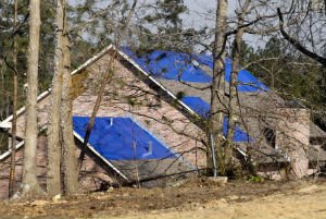 house with tarp on roof