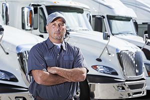 A truck driver next standing next to semi-trucks