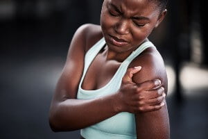 person holding sore shoulder