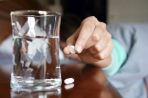 sleeping pills next to a glass of water