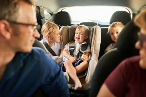 driver looking into the backseat at children