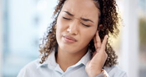 stock image of young woman with ear pain