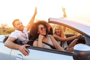 Teens in car singing and dancing