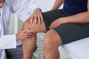 doctor evaluating patient knee injury