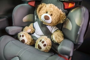 close-up of child safety seat with a teddy bear strapped in