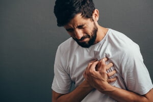 young man feeling pain from broken ribs after a crash