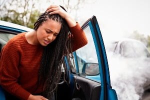 young african american woman holding her head after a crash
