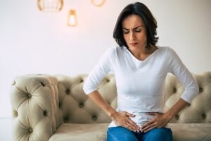 adult woman with hernia holding her abdomen in pain