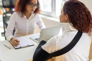 A woman in a office with someone injured.