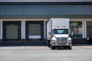 Truck backing up into a warehouse dock.