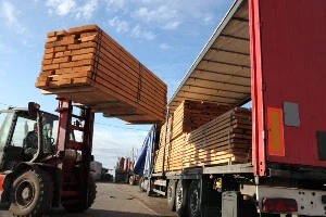 A truck being filled with wood panels.