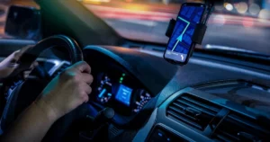 A rideshare drivers phone on the dashboard of their car.